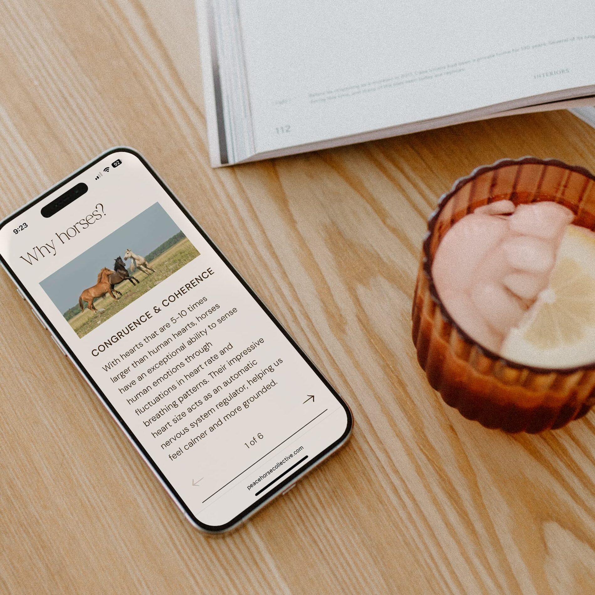 Clean, modern mobile website design for equine therapy website with a warm, minimalist aesthetic displayed on a phone over a natural wood surface.